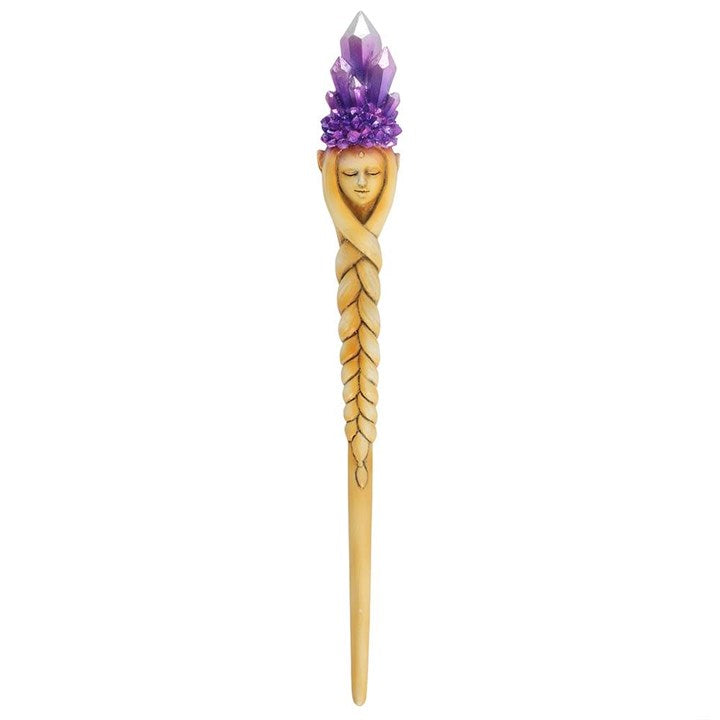 Hair stick with purple crystal and face design on a white background