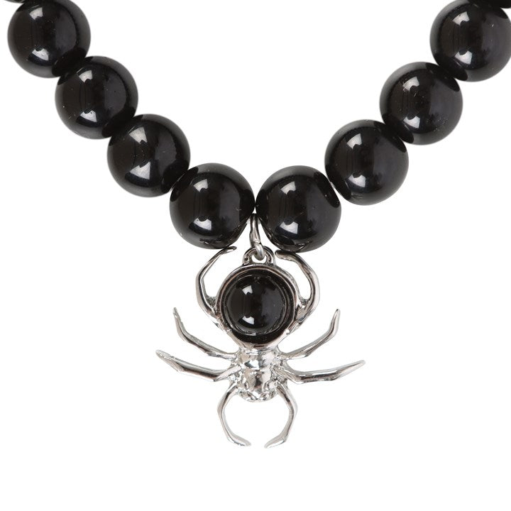 Black beaded necklace with a spider charm on a white background