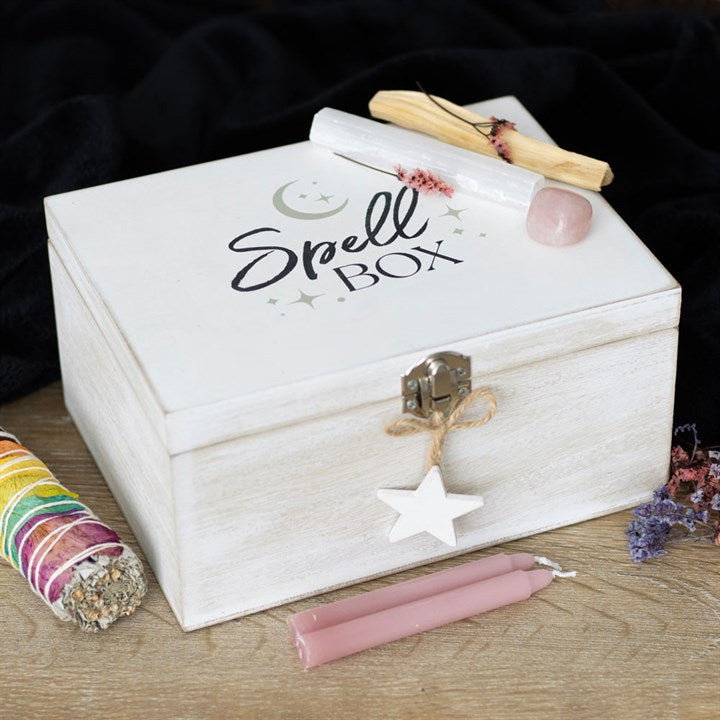 White wooden box labeled 'Spell Box' with wands and candles on a dark background