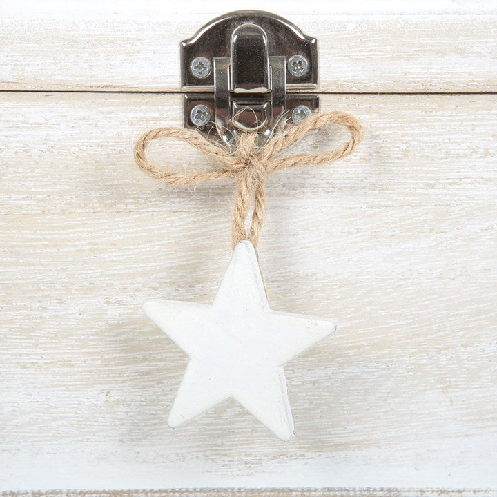 White star ornament hanging from a wooden latch on a light wood surface